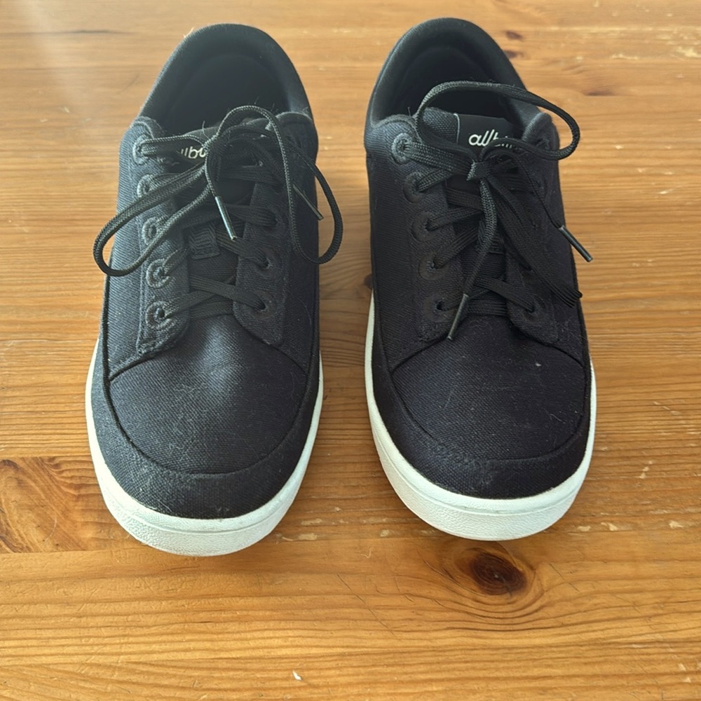 Allbirds black athletic shoes.